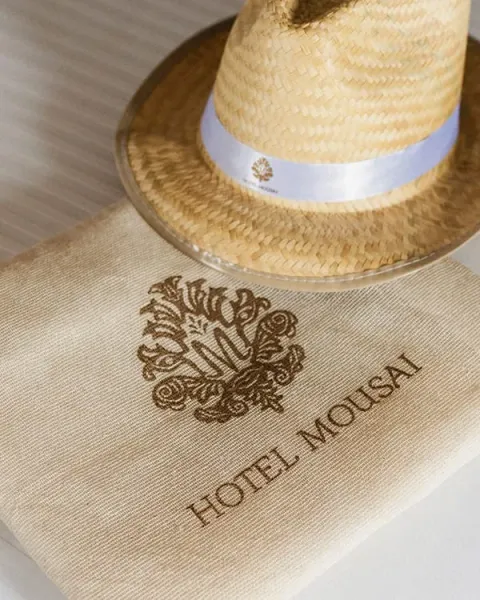 Sombrero y bolsa con el logotipo de Hotel Mousai.